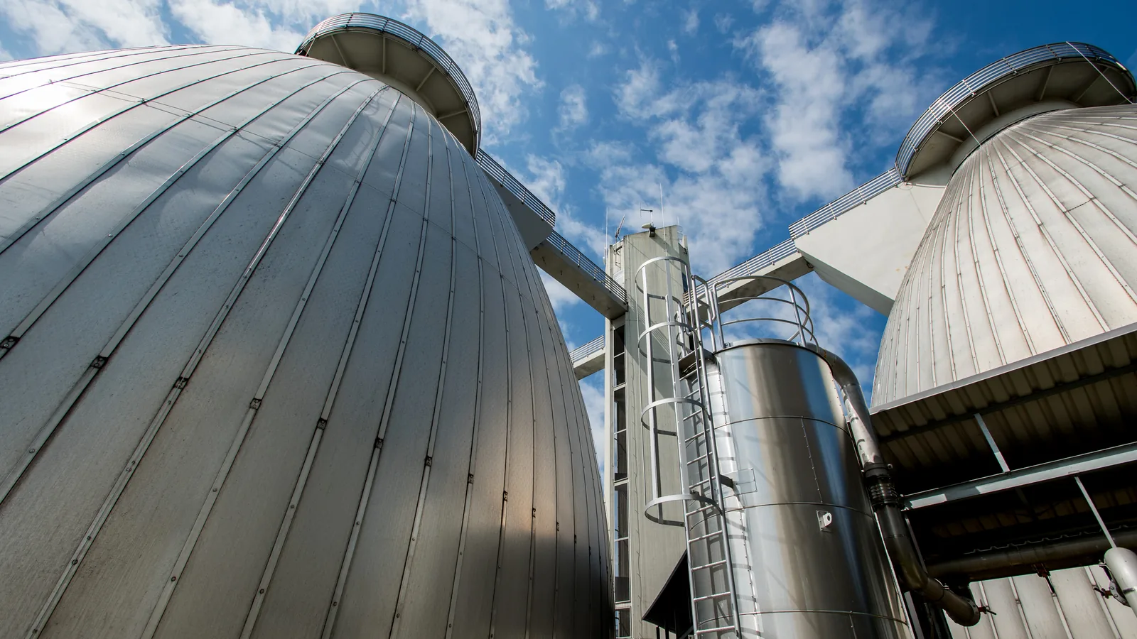 Digesters of a digestion plant against a blue sky