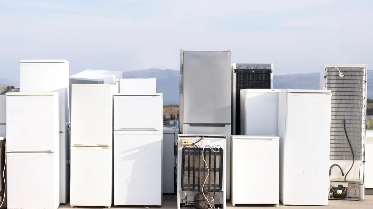 Discarded refrigerators lined up at a recycling yard
