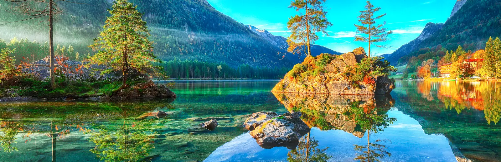 Bergsee mit Spiegelung von Baum und Berg – intakte Natur als Grundlage nachhaltigen Wirtschaftens