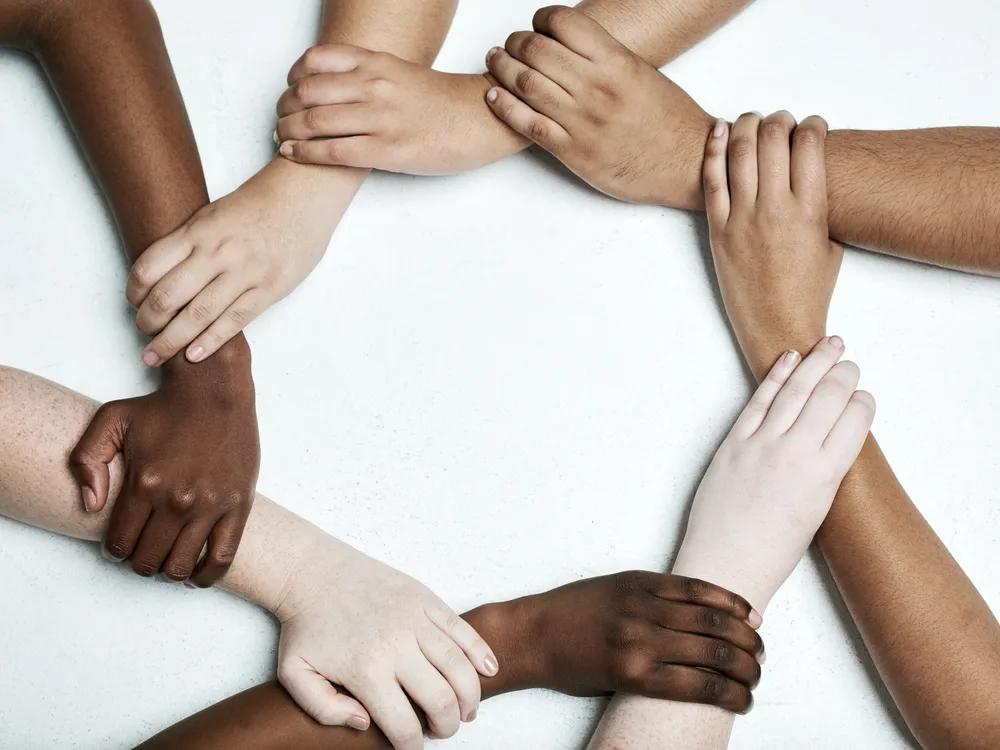 Verschränkte Arme im Kreis – Partnerschaften und gemeinsame Ziele